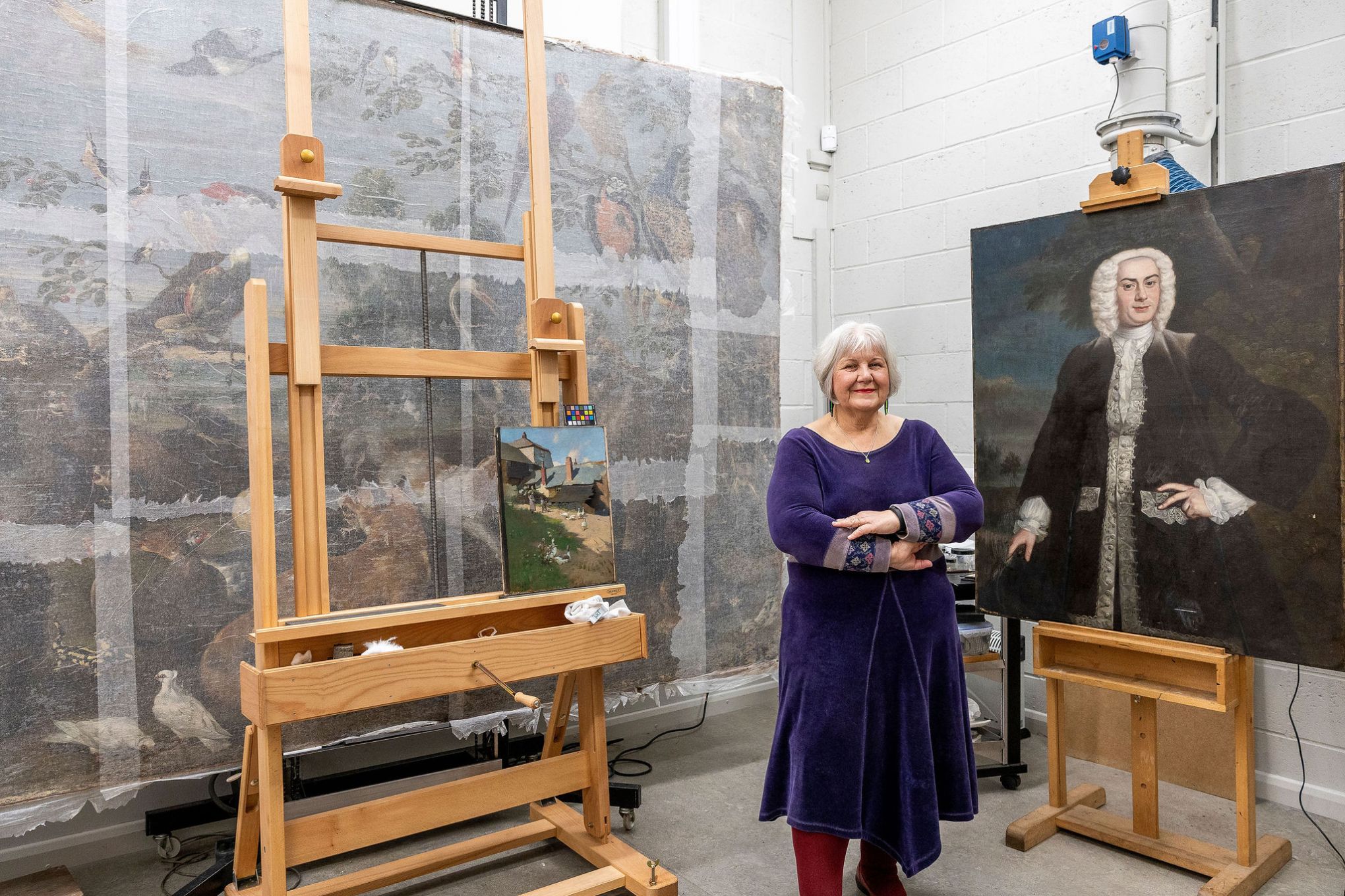 Juile Bell posing with a portrait at the Conservation Studio, Preston. Image by Christina Davies, Fish2Photo.