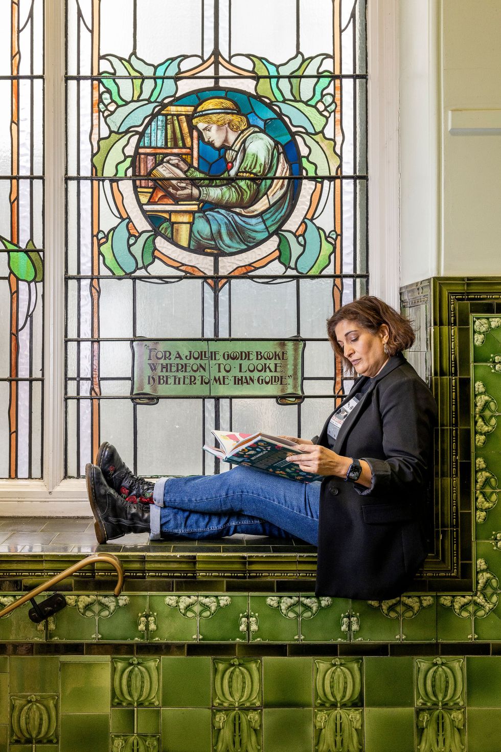 Mina Anwar sits in front of the stained glass window at Accrington Library. Image by Christina Davies. Fish2Photo.